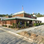 Texas Roadhouse restaurant with green metal roof and parking lot in Hiram, GA.